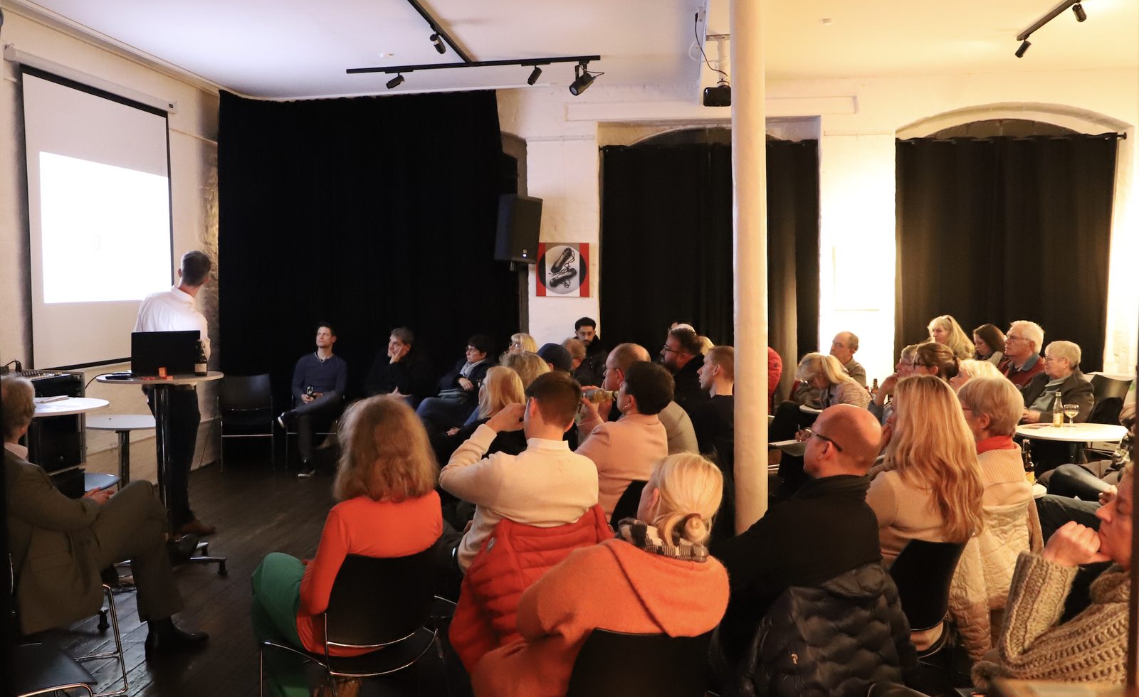 Voll besetzter Saal in der Bandfabrik bei der Gründungsversammlung, vorne ein Redner
