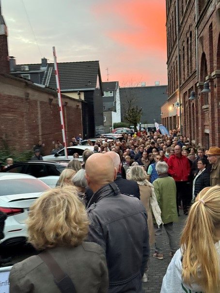 Lange Schlange vor dem Eingang in der Abenddämmerung